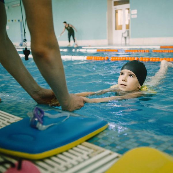 coach-teaching-kid-indoor-swimming-pool-how-swim-dive-swimming-lesson-kids-development (1)