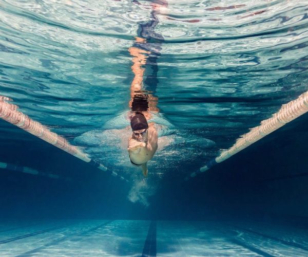 underwater-picture-of-young-swimmer-in-cap-and-gog-BNWUZ9V-1024x683